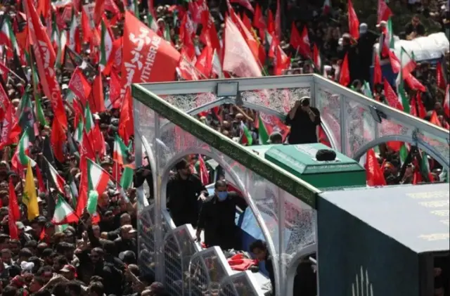 Imodoka ireruye isandugu y'ikiziga ca Ayatollah Ali Khamenei yari ikikujwe n'abari mu rugendo rwo kumusezera 