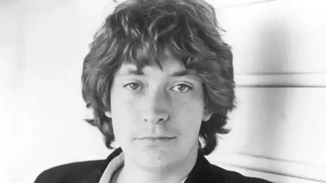 Чорно-біле фото молодого Кріса Рі з волоссям середньої довжини