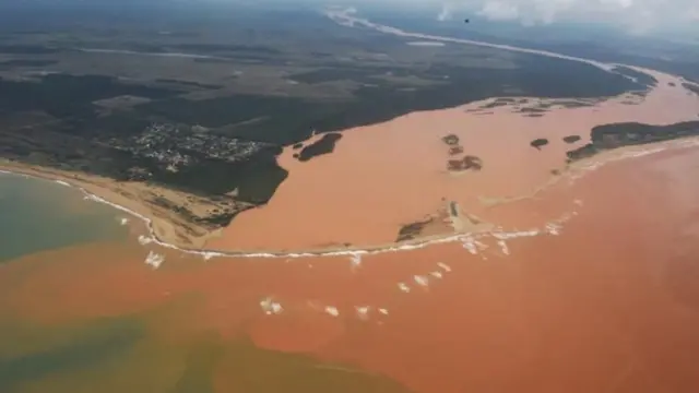 Rio cheio de lama desaguando no oceano