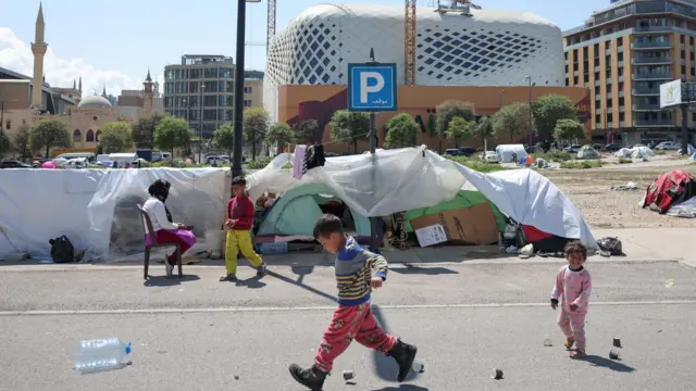 Lübnan'ın başkenti Beyrut'taki derme çatma kampta, yerinden edilmiş çocuklar çadırlarının yanında oyun oynuyor.
