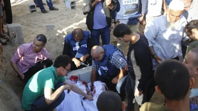 하얀 천에 싸인 시신을 만지는 알-다흐두흐 기자