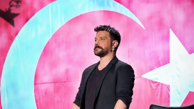 Oğuzhan Uğur, Türk bayrağının önünde ayakta duruyor