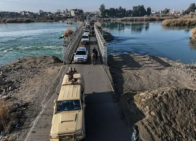 Suriye'nin doğusundaki Deyrizor vilayetinde Fırat Nehri'nin doğu ve batı kıyıları arasındaki köprüden araçlar geçiyor. 