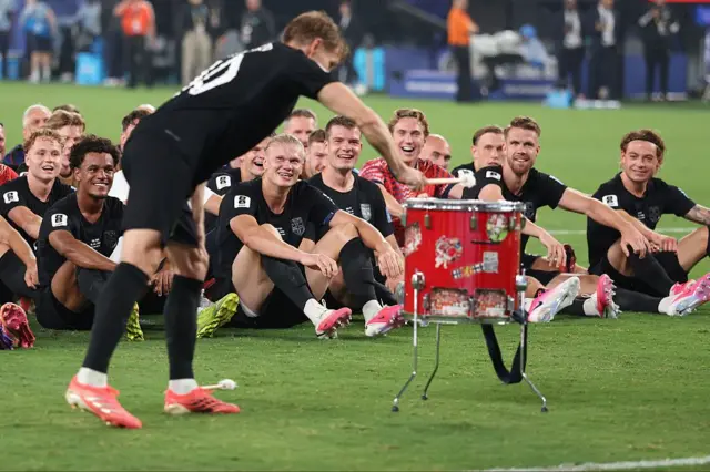 Martin Ødegaard, da Noruega, toca um tambor e, ao fundo, estão outros jogadores da equipe norueguesa, que executam a "remada viking" em campo