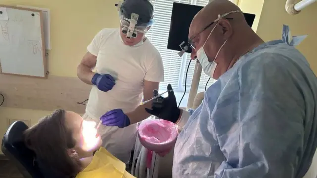 Diş hekimi Volodimir Stefaniv ameliyat sırasında elektrik kesintileriyle uğraşmak zorunda kalıyor