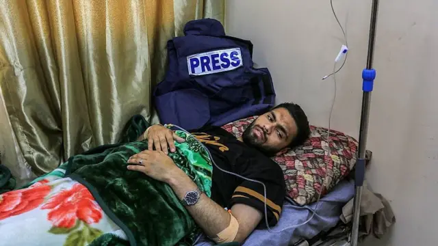 Fotojornalista palestino Abdullah al-Atance em uma maca, depois de ser ferido em um ataque israelense em abril de 2025