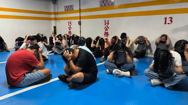 Osoby w Kinmen siedzą na podłodze z rękami nad głowami, w ramach jednego z ćwiczeń