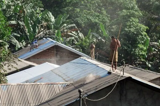 Warga Desa Hikong membersihkan atap rumahnya dari abu dampak erupsi Gunung Lewotobi Laki-laki di Kecamatan Talibura, Kabupaten Sikka, NTT, Rabu (18/06).
