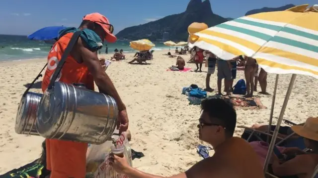 Vendedor de mate servindo cliente em praia do Rio de Janeiro