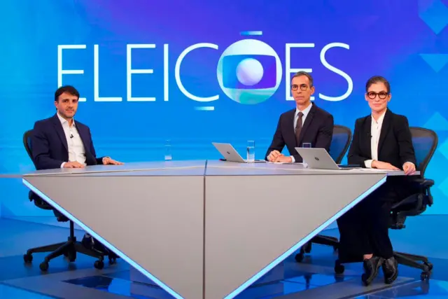 Renan Santos, César Tralli e Renata Vasconcellos na bancada da TV Globo