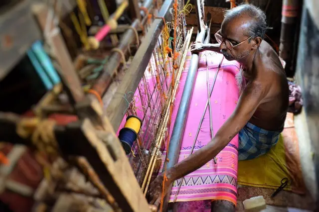 টাঙ্গাইল তাঁত পল্লিতে শাড়ি বুনছেন এক তাঁতি। 