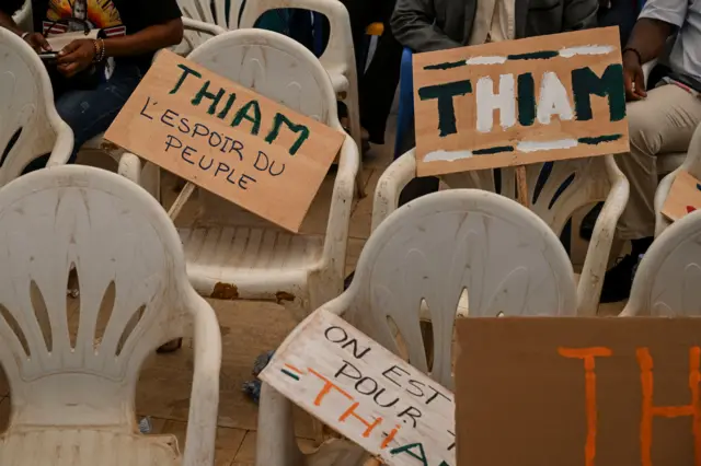 Des chaises vides avec des banderoles portant des messages pour le président du Parti démocratique de Côte d'Ivoire (PDCI), principal parti d'opposition, Tidjane Thiam, sont vues lors d'une réunion du bureau politique avant l'élection présidentielle à Yamoussoukro le 5 avril 2025.