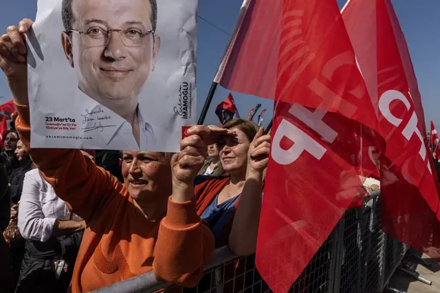 Ekrem İmamoğlu'nun resmini kaldıran bir kadın, CHP bayrakları