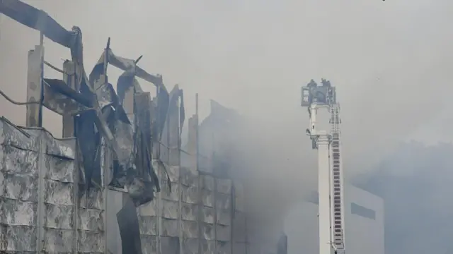 Пожарные работают на месте пожара в промышленном парке, где хранились гуманитарные грузы, после российского нападения на Львов, Украина, 5 октября 2025 года.