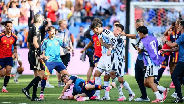Leandro Parades es apartado por sus compañeros mientras un jugador español yace en el suelo a sus pies.