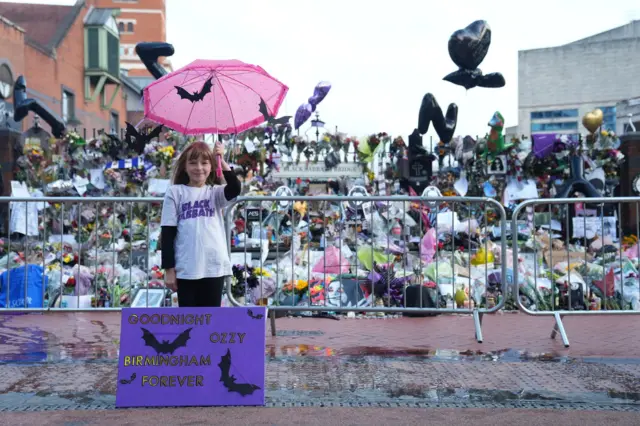 Eliza Finn-O'shea, de 10 años, posa junto a un cartel con murciélagos en el que recuerda a Ozzy Osbourne
