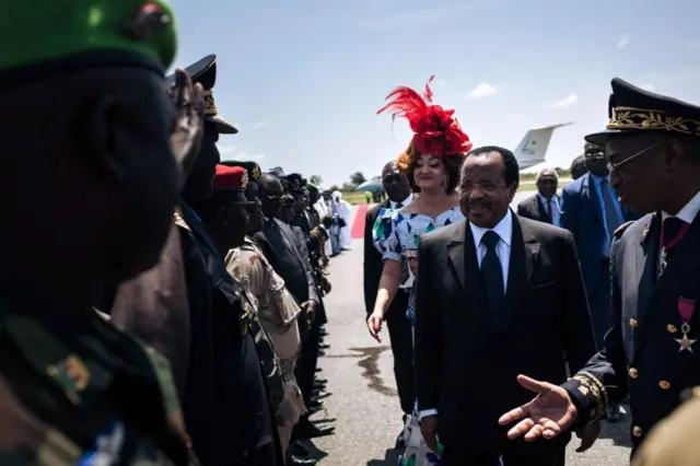 Le président camerounais Paul Biya accompagné de son épouse Chantal Biya, salue les forces militaires à son arrivée à l'aéroport de Maroua lors de sa visite électorale dans la région de l'Extrême-Nord du Cameroun, le 29 septembre 2018. 