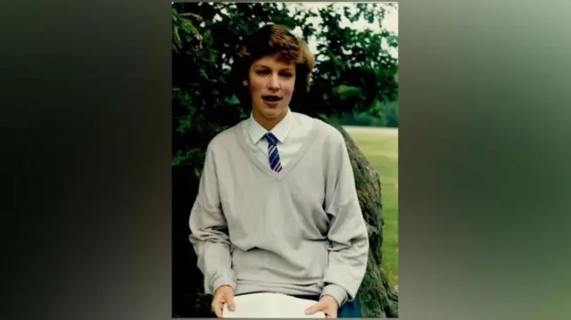 Katie Mitchell jovem, em uniforme escolar
