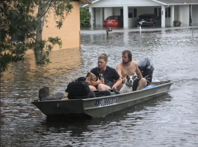 Warga mengungsi dari Magnolia Avenue setelah Badai Milton membanjiri lingkungan di South Daytona, Florida, AS, pada 10 Oktober 2024.