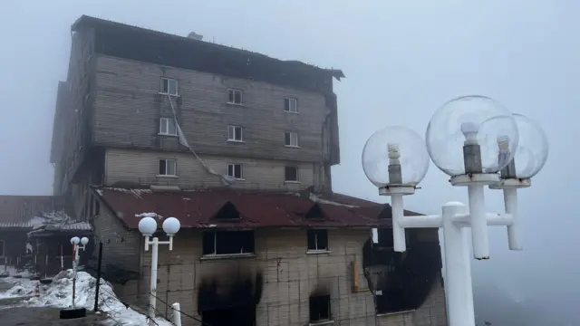 Yanan otelin arka planda sisli görüntüsü. 