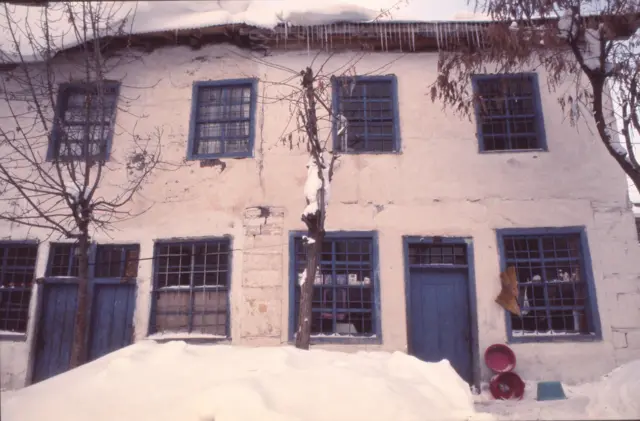 Pülümür'deki iki katlı bir ev. Önüne karlar yığılmış. Çatıda buz sarkıtları var. 