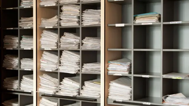 Bir kitaplığa yığılmış mahkeme dosyaları.