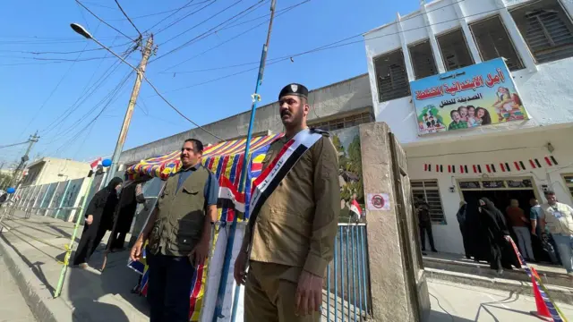 یک مامور از حوزه اخذ رای حفاظت می‌کند 