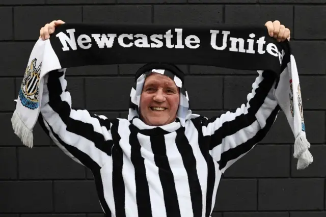 Un supporter de Newcastle United assiste à un match en portant un costume arabe aux couleurs du club.