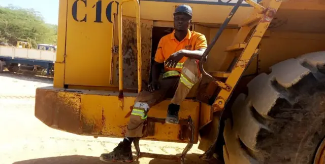 Dame Wilane assis sur un engin lourd.