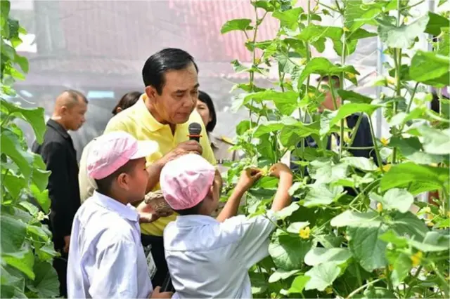 Prayut Chan-o-cha em plantação com alunos, em visita à escola