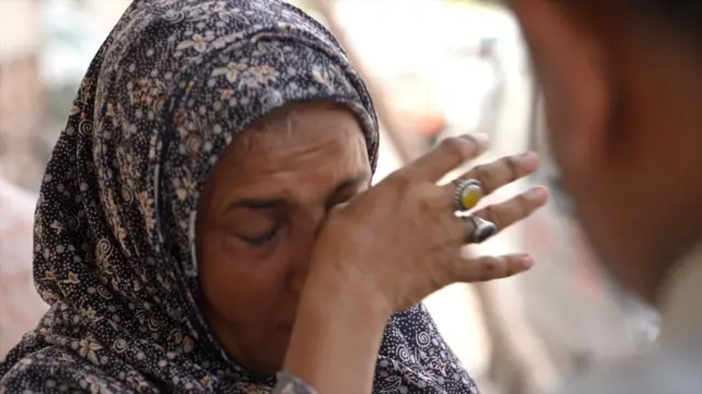 Karachi - Pakistan: umugore aririra umugabo yahohoshejwe n'ubushuhe.