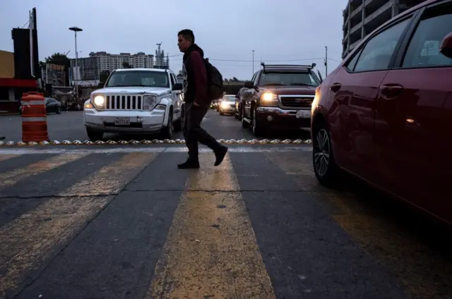 Un homme traversant la route avec un sac à dos avec des véhicules proches de lui