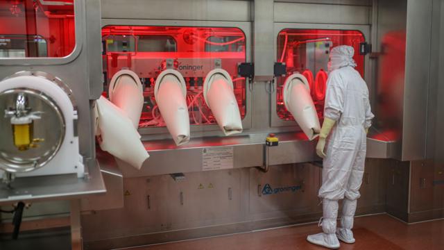 An employee monitors the production line for Covishield, the local name for the Covid-19 vaccine developed by AstraZeneca and the University of Oxford, at the Serum Institute of India's Hadaspar plant in Pune, Maharashtra, India, on 22 January 2021