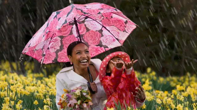 African mother and daughter dey play inside di rain