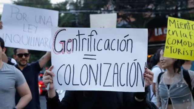 Imagemjogar truco online gratisuma manifestaçãojogar truco online gratisque uma pessoa segura um cartaz escrito 'gentrificação = colonização',jogar truco online gratisespanhol