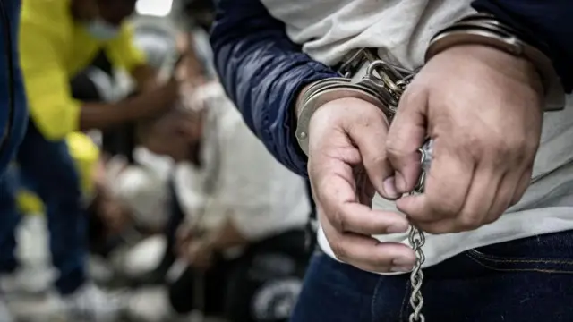 Manos esposadas de uno de los presos del Cecot, en El Salvador