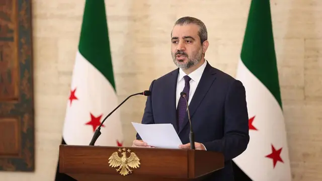 Suriye Dışişleri Bakanı Esad Hasan Şeybani ve Uluslararası Atom Enerjisi Ajansı (UAEA) Genel Direktörü Rafael Mariano Grossi (görünmüyor), 18 Ağustos 2026'da Suriye'nin başkenti Şam'da ortak bir basın toplantısı düzenliyor.

