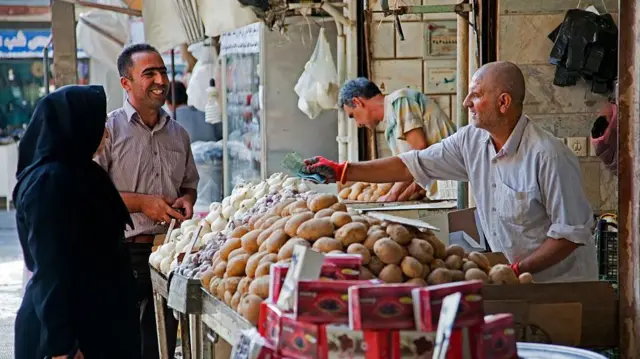 زن ایرانی مشغول خرید سیب زمینی در گرگان