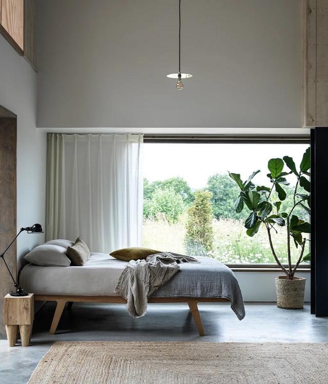 Cama com colchão em quarto com janela grande