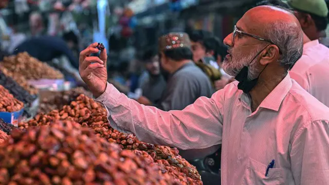 ایک شخص کھجور کا معائنہ کر رہا ہے