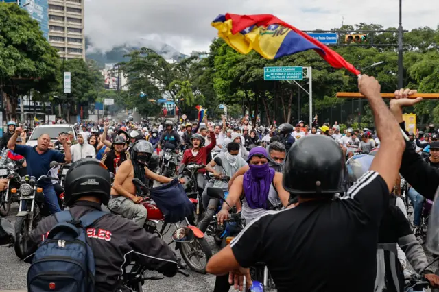 People ride through the streets on motorcycles during a protest against the results of the presidential elections, in Caracas, Venezuela