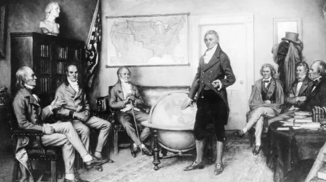 一幅約製於1823年的黑白畫作描繪當時的美國總統詹姆斯·門羅站在一個大型地球儀前,周圍環繞著身穿當時服飾的政界同僚