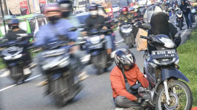 Seorang pemudik tengah memperbaiki sepeda motornya di jalur Pantura, Simpang Jomin, Karawang, Jawa Barat, Rabu (19/04). Pemudik yang menggunakan sepeda motor maupun kendaraan roda empat dari arah Jakarta menuju Jawa Tengah terpantau semakin padat.