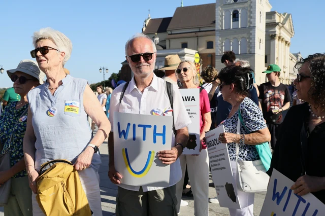 жінки і чоловік ьеруть участь в акції на підтримку українців в Польщі