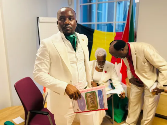 Samuel Ndayiragije i bubamfu muri costume yera n'igishora mw'izosi ari kumwe n'abandi babiri bitavye Burundi Day, Bruxelles, ku wa 26 Gitugutu 2024