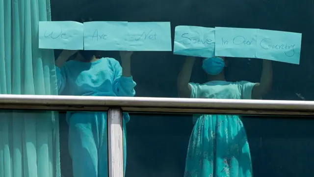 Desde una de las ventanas del Hotel Decápolis de Ciudad de Panamá, dos migrantes mostraban letreros con el mensaje: "No estamos seguras en nuestro país"