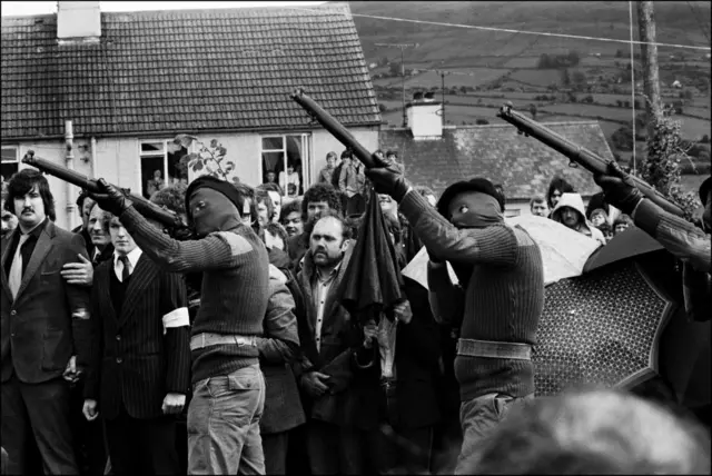 1981 yılındaki bir cenaze törenine silahlarıyla katılan IRA üyeleri
