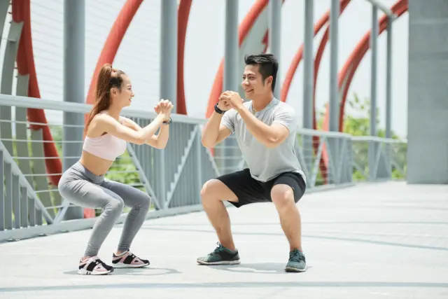 Hai người thực hiện động tác squat tại TP HCM