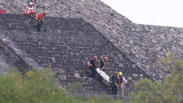 Paramédicos cargan una camilla con lo que se asume es un cuerpo cubierto por las escaleras de la pirámide de la Luna.