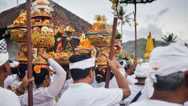 Балийцы возвращаются домой с подношениями после церемонии полнолуния Пурнима в Меласти, Амед.